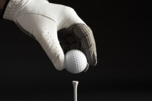 hand-with-glove-holding-golf-ball